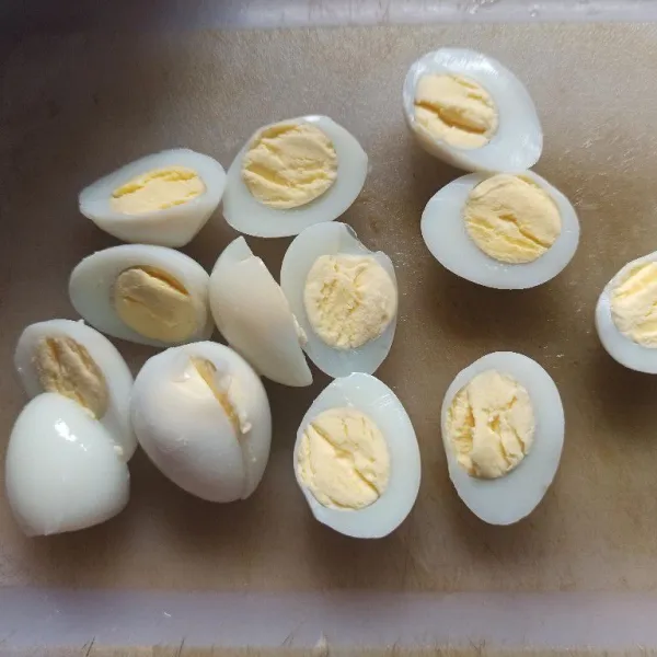 Belah telur puyuh menjadi 2 bagian.