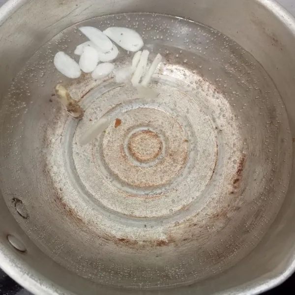 Rebus air hingga mulai mendidih lalu masukkan bawang putih dan kunci.