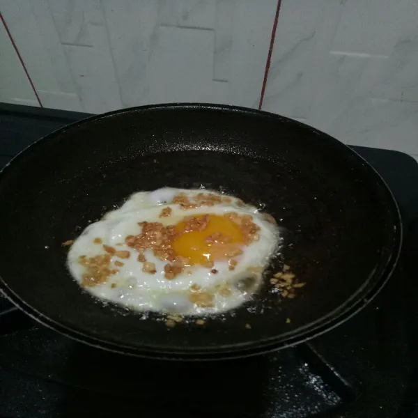 Beri taburan bawang putih goreng tadi dan masak telur hingga matang.