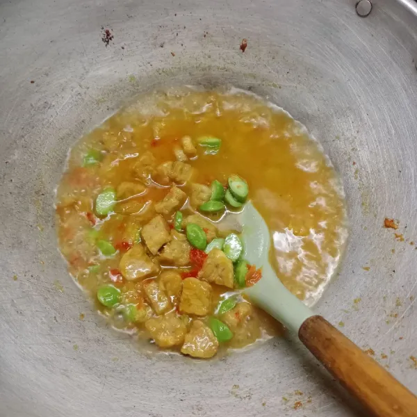 Masukkan tempe dan air. Masak sampai petai empuk.