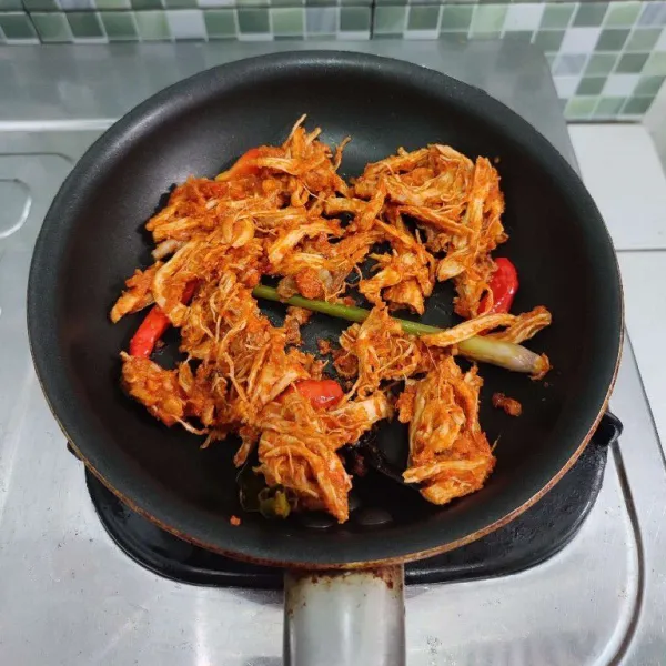 Panaskan minyak goreng, tumis bumbu halus bersama serai, daun salam, dan daun jeruk hingga wangi. Masukkan kaldu bubuk dan garam. Aduk rata. Kemudian masukkan ayam suwir dan sedikit air. Lalu tambahkan cabe rawit utuhan. Aduk rata. Masak hingga bumbu meresap, kemudian matikan api.