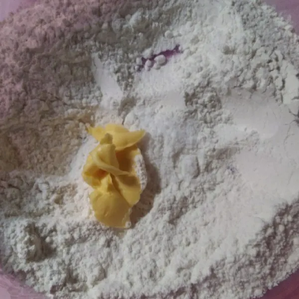 Siapkan tepung terigu dalam wadah, lalu tambahkan margarin. Aduk sampai bergerindil.