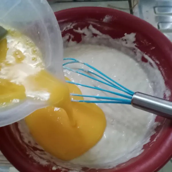 Setelah 30 menit, kocok telur dan gula pasir (1). Kemudian tuang kedalam adonan, aduk rata.