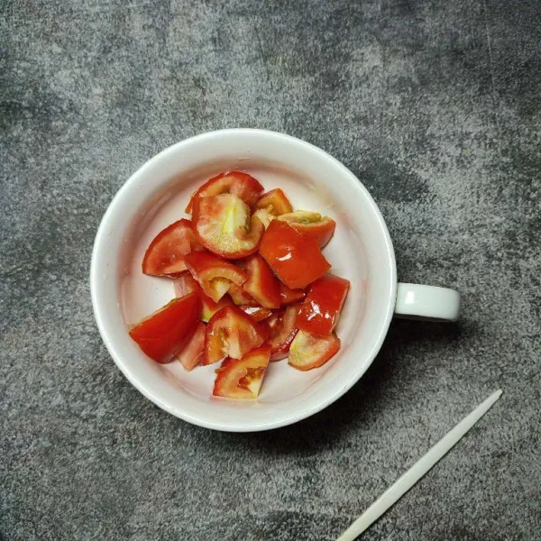 Potong kecil-kecil tomat kemudian masukkan ke dalam piring saji.