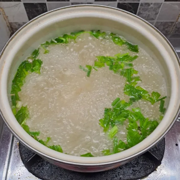 Rebus air, bawang putih, daun seledri dan daun bawang sampai mendidih.