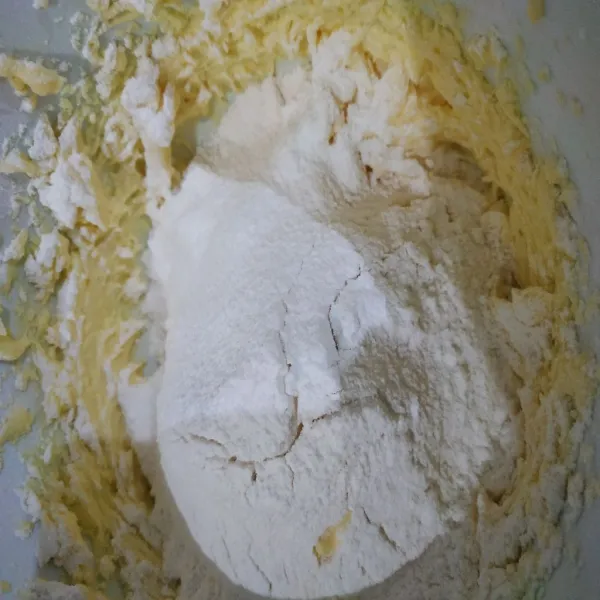 Ayak tepung terigu, garam, baking soda dan baking powder ke atas adonan butter. Lalu aduk dengan spatula, masukkan chocochips, aduk kembali.
