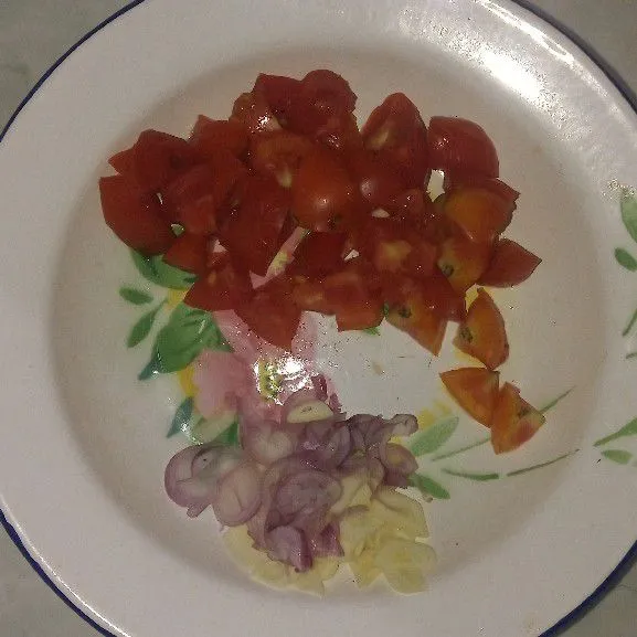 Potong tomat dan iris tipis tipis bawang putih dan bawang merah