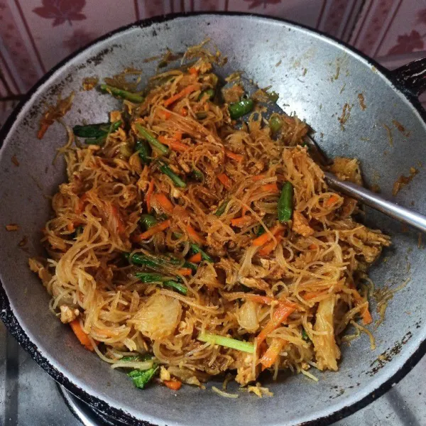Selanjutnya masukkan bihun dan sawi, aduk rata dan masak hingga bumbu meresap.