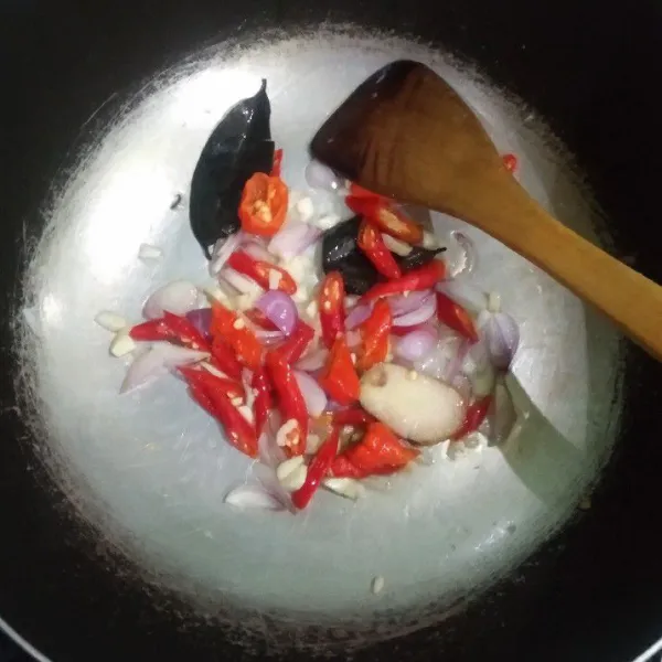 Tumis bawang putih, bawang merah, cabe, lengkuas, dan daun salam hingga wangi.