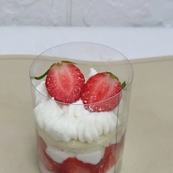 Beri whipped cream kembali dan potongan strawberry.
