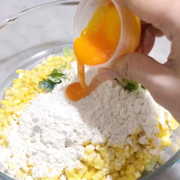 Campurkan jagung, kuning telur, daun bawang, dan tepung bakwan instan.