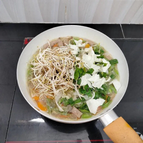 Masukkan tauge, kubis, daun seledri, daun bawang prei, kaldu bubuk, merica bubuk dan garam. Aduk rata dan masak hingga mendidih.