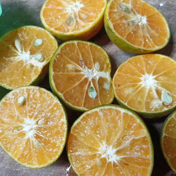 Potong melintang buah jeruk, lalu peras dan ambil airnya.