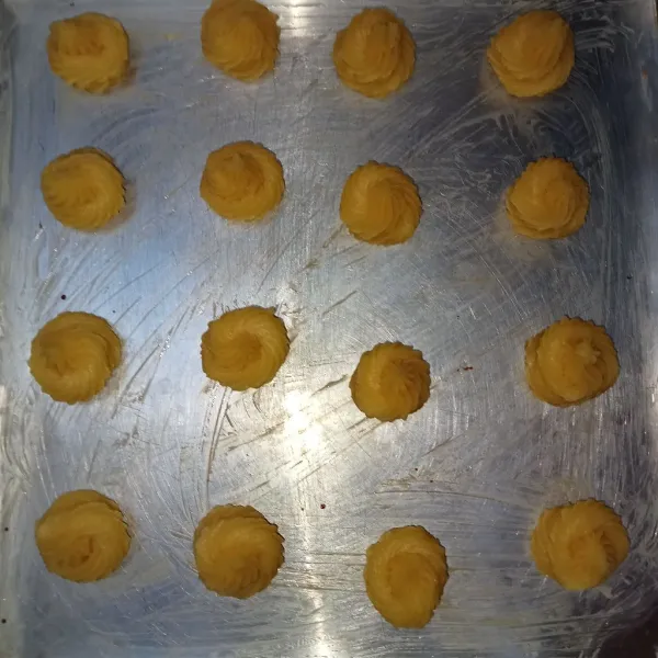Tuang adonan kedalam piping bag kemudian semprotkan adonan diatas loyang yang sudah diolesi dengan margarin (saya semprot kecil kecil supaya sekali suap).