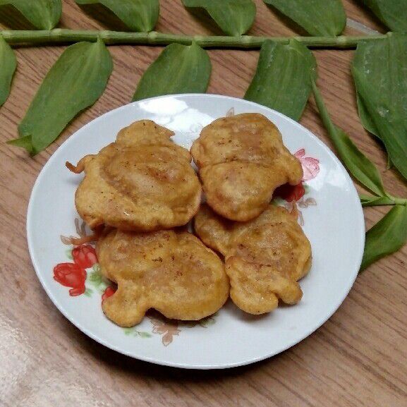 Gulai pisang dalam piring dengan taburan bawang goreng dan daun seledri