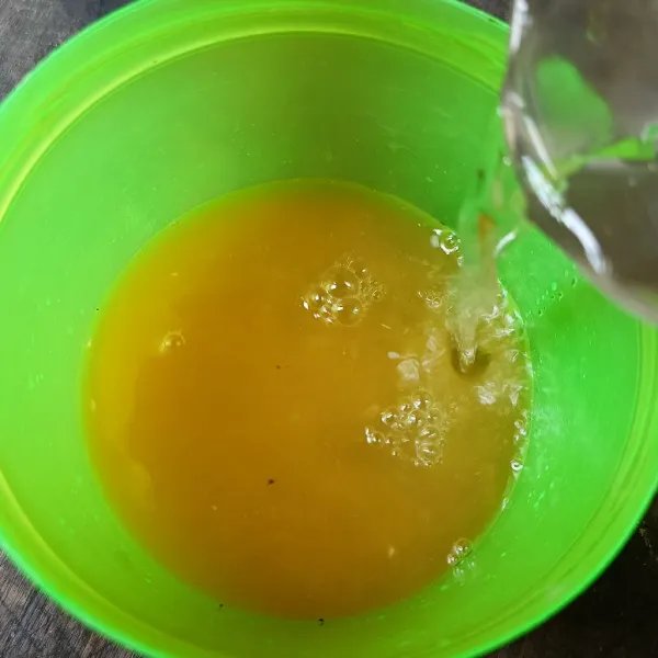 Tambahkan air matang ke dalam air perasan jeruk.
