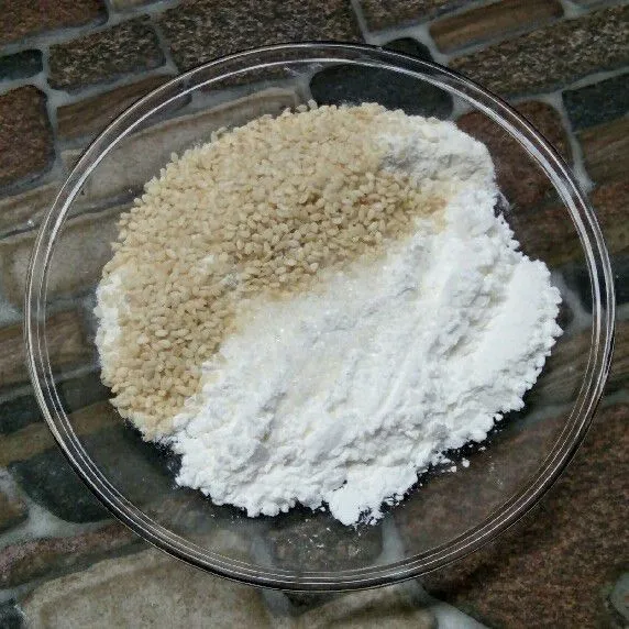 Masukkan kelapa parut, tepung terigu, tepung beras, gula pasir, wijen, dan baking powder ke dalam wadah.
