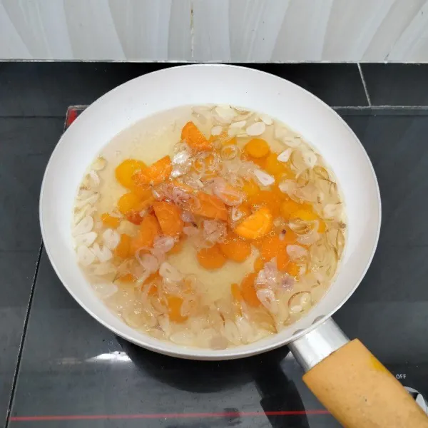 Lalu masukkan air dan wortel. Masak hingga mendidih.