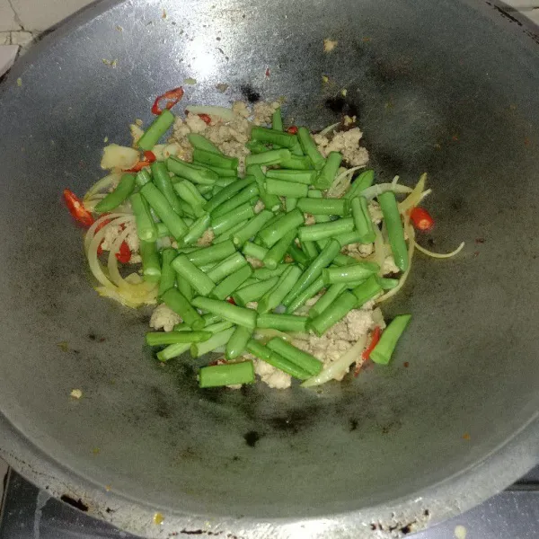 Tambahkan buncis, aduk hingga buncis berubah warna kemudian beri air, masak sampai air mendidih dan menyusut.