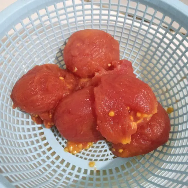 Tiriskan tomat sampai suhunya turun, lalu kupas kulitnya.