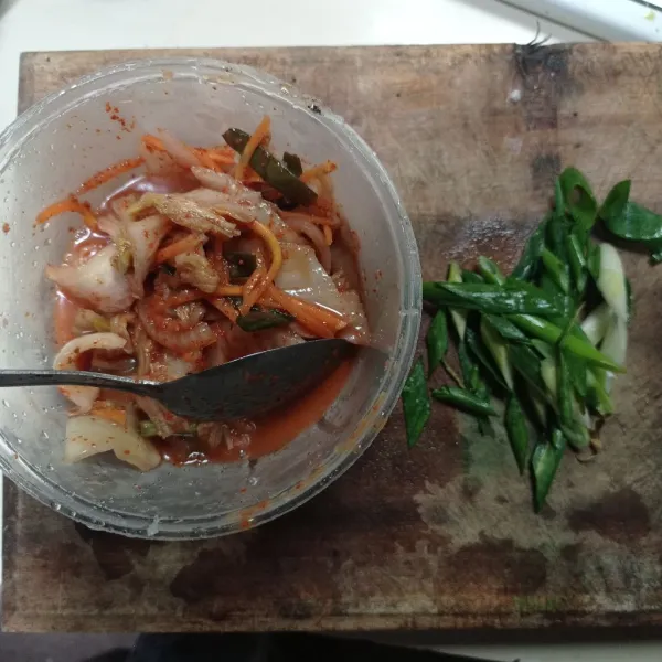 Siapkan kimchi lalu potong kecil kecil, Iris menyerong daun bawang.