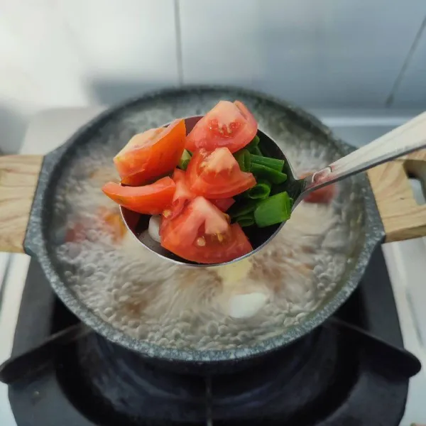 Masukkan potongan daun bawang dan tomat, sesaat sebelum kompor dimatikan. Sajikan hangat.