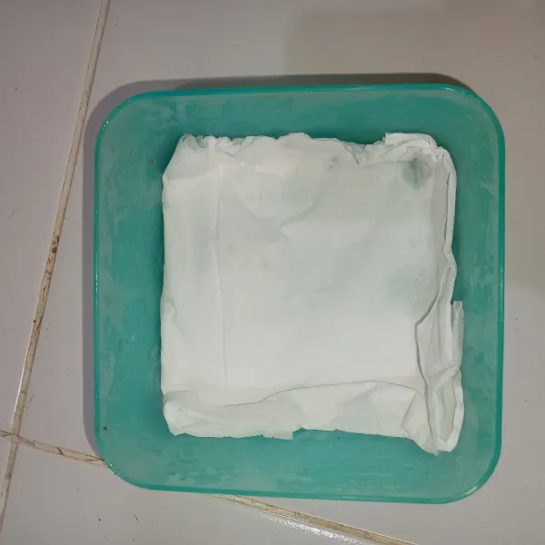 Letakkan tisu di dalam wadah yang akan digunakan untuk menyimpan.