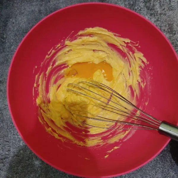 Kemudian masukkan kuning telur dan pasta vanila, kocok kembali hingga rata.