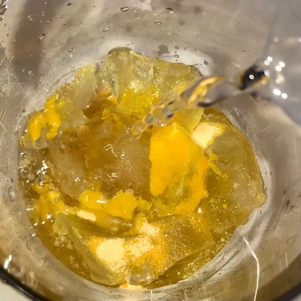 Kocok bubuk minuman rasa jeruk dengan air dan es batu.
