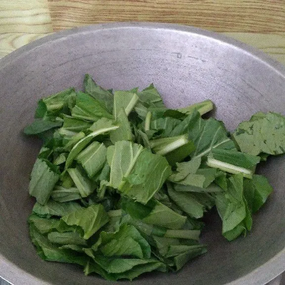 Masukkan daun caisim lalu aduk.