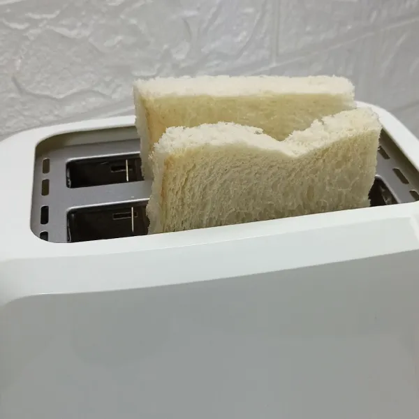 Masukkan roti ke dalam toaster.