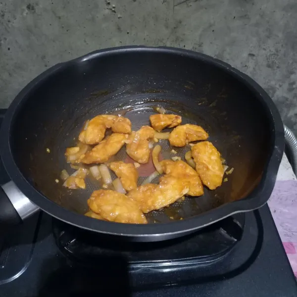 Masukkan ayam goreng ke dalam saus dan aduk sampai rata.