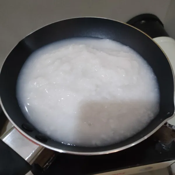 Masukkan ke pan, beri 200 ml air dan kaldu jamur, masak hingga bubur mendidih.