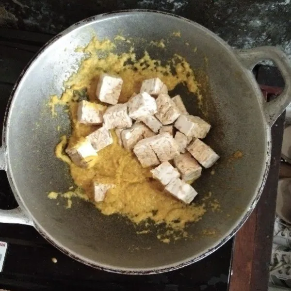 Masukkan tempe. Tumis hingga tercampur merata. Masukkan santan dan aduk-aduk hingga mendidih.