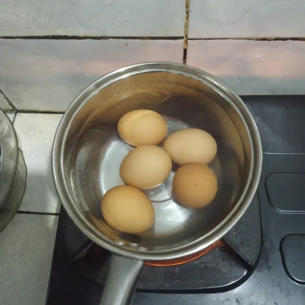 Rebus telur selama 15 menit, lalu kupas cangkangnya.