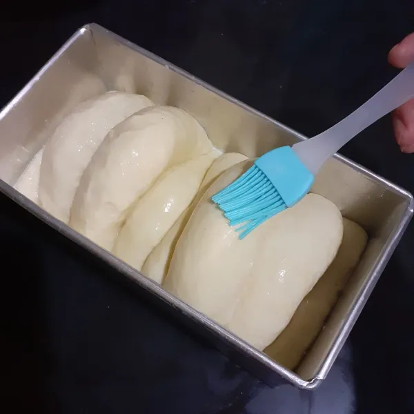 Biarkan mengembang 3 kali lipat. Olesi susu cair.