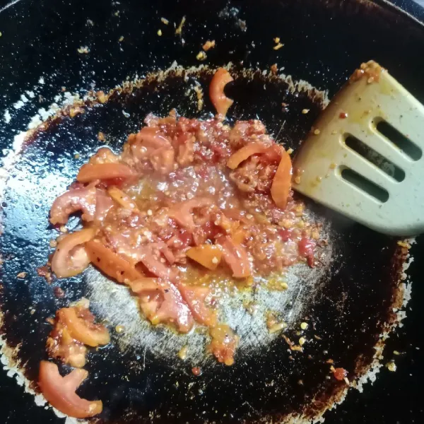 Panaskan sedikit minyak. Tumis bumbu halus sampai harum dan matang. Kemudian masukkan tomat, aduk rata.