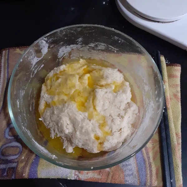 Masukkan margarin yang sudah dicairkan, aduk. Lalu lipat dan tekan-tekan adonan hingga margarin terserap.