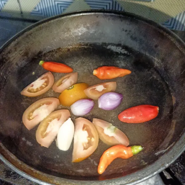 Rebus cabai, tomat, bawang merah dan bawang putih sampai layu.