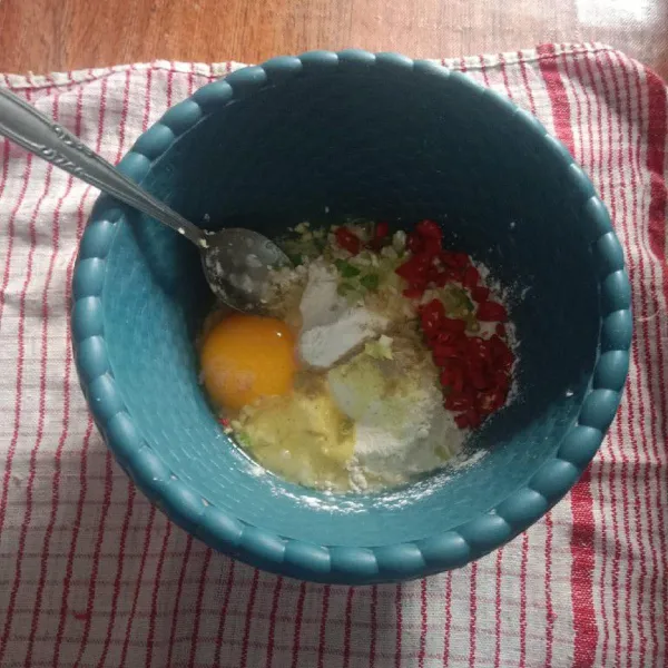 Tambahkan 1 butir telur, lada bubuk, penyedap, garam, bawang putih yang sudah dihaluskan, cabe merah, aduk rata.