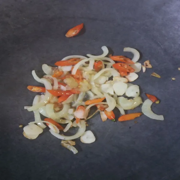 Panaskan secukupnya minyak goreng. Tumis bawang putih, bawang bombay, dan cabe rawit sampai harum.