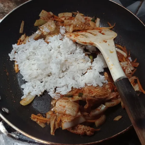 Masukan nasi, lada bubuk dan kaldu bubuk, aduk rata.
