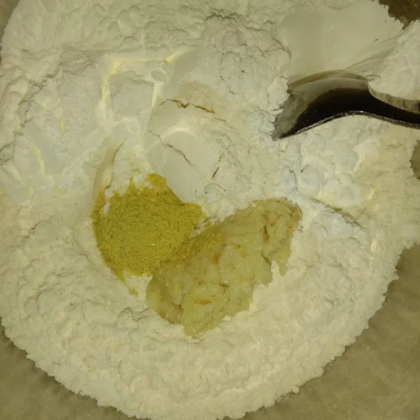 Campur jadi satu semua tepung dalam wadah, tambahkan bumbu halus, garam, dan kaldu bubuk.