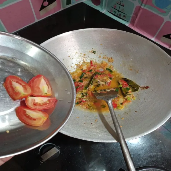 Tambahkan air secukupnya, lalu masukkan irisan tomat.