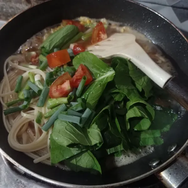 Masukan spaghetti, caisim, tomat, dan daun bawang.