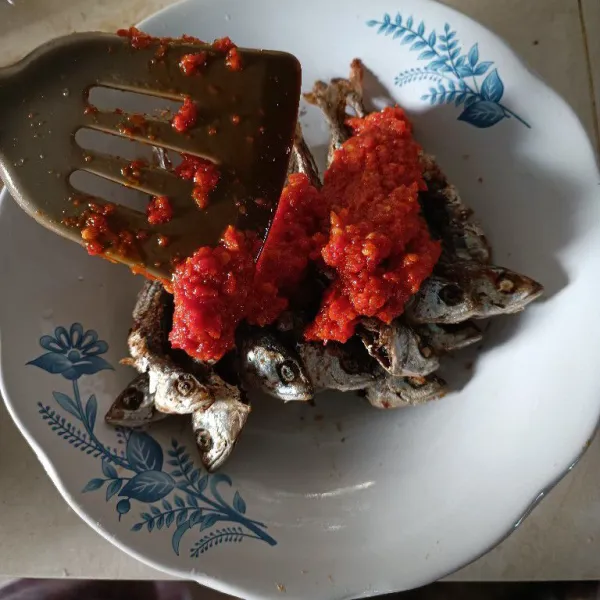 Tunggu cabe agak hangat, kemudian tuang di atas ikan goreng.