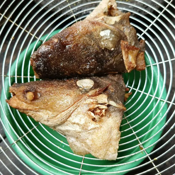 Bumbui kepala ikan sesuai selera, lalu goreng sampai matang, angkat dan tiriskan.