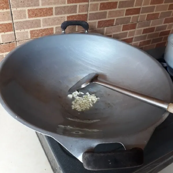 Tumis bawang putih dengan minyak hingga harum.