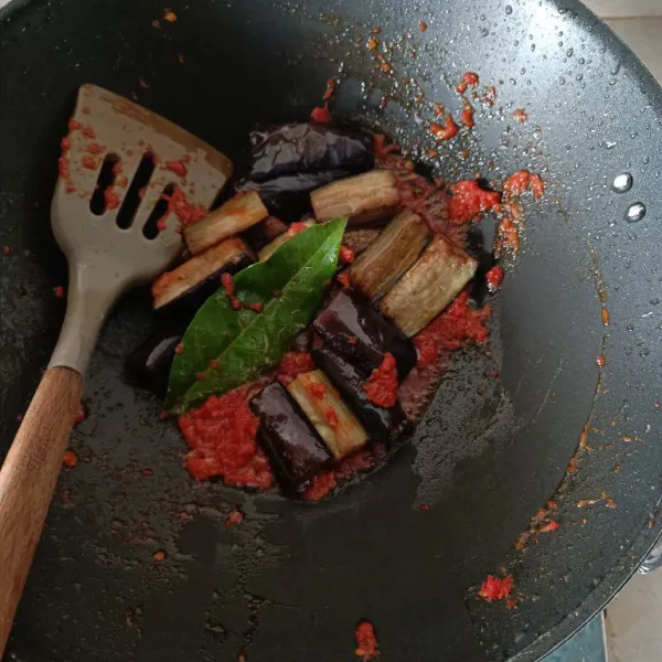 Masukkan terong dan daun salam aduk rata. Masak sebentar hingga daun salam berubah warna aduk kembali. Tes rasa lalu matikan api.