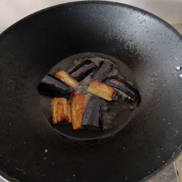 Goreng terong dalam minyak panas hingga berubah warna dan empuk.